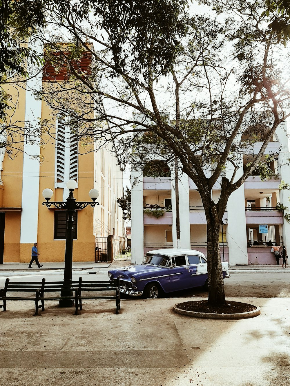 blue sedan parked near white building during daytime