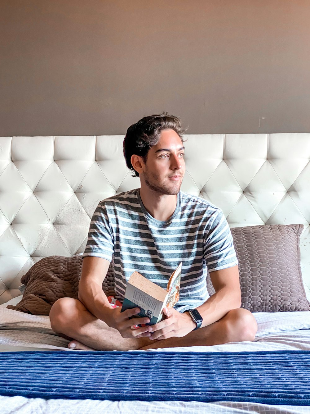 man in white and black stripe polo shirt reading book