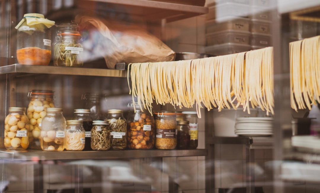 brown and white banana on clear glass container, Handmade pasta hanging in the window of a restaurant
