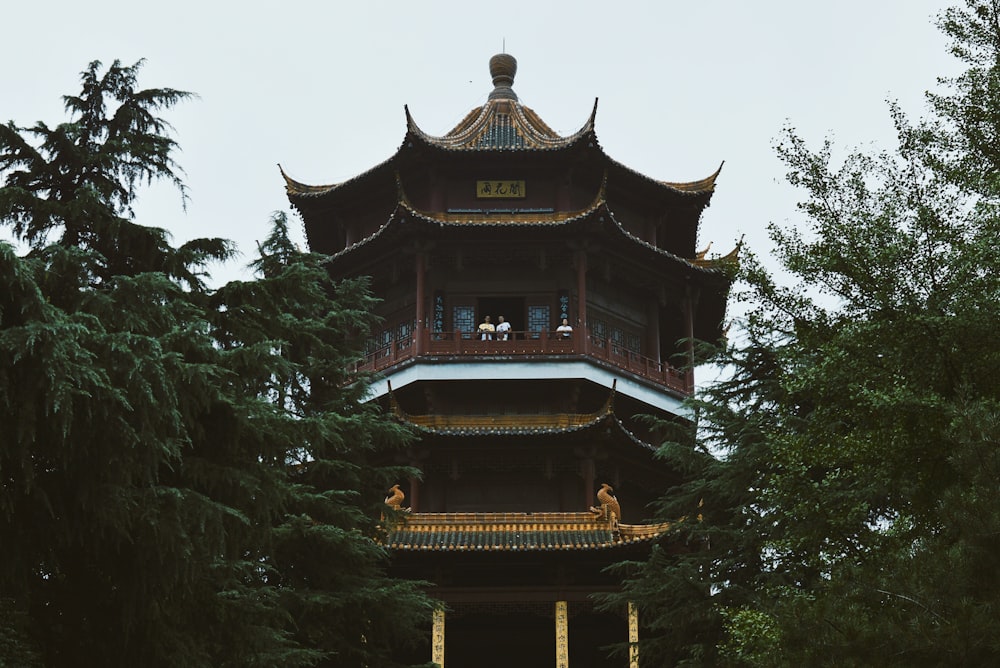 Brauner und schwarzer Tempel, tagsüber von grünen Bäumen umgeben