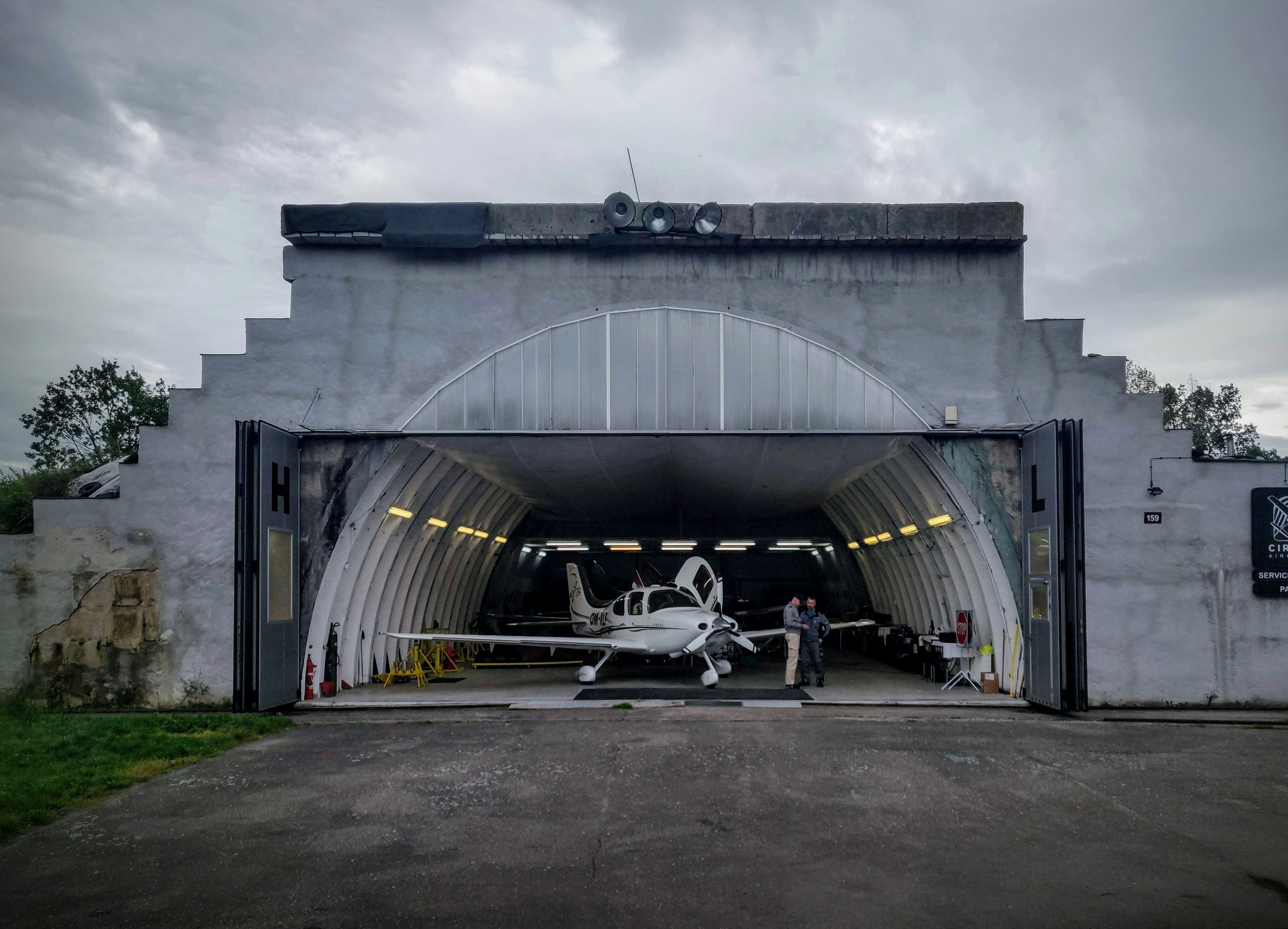 black and white drone flying over gray building