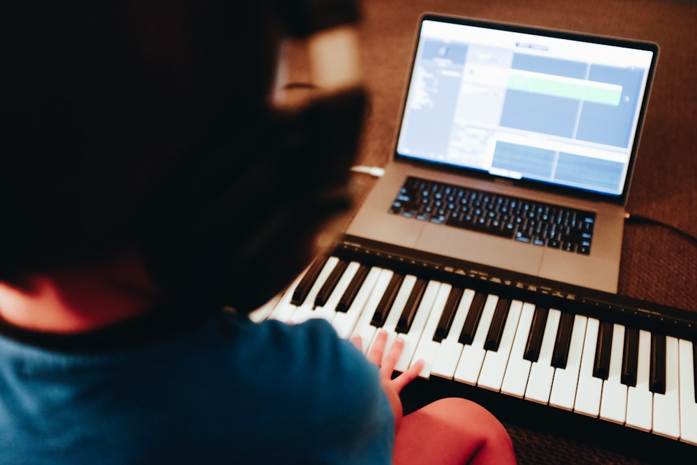 person in blue shirt near black and white piano