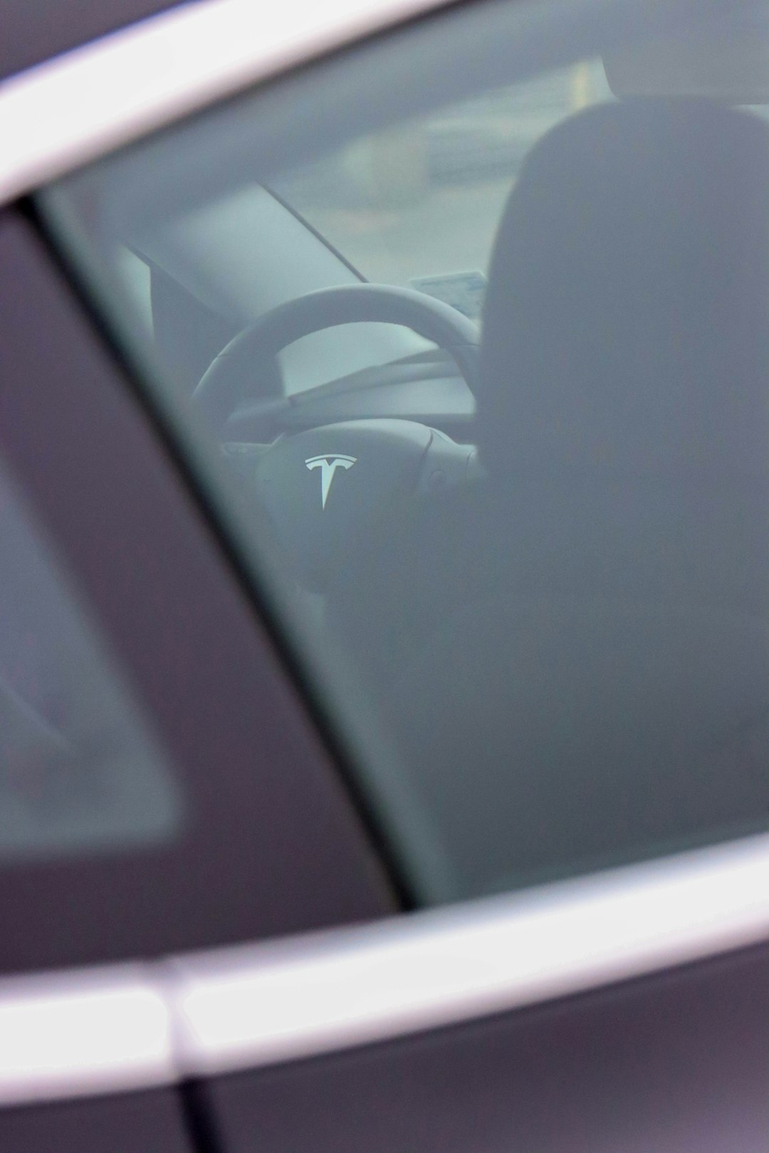 person in black pants sitting on car seat