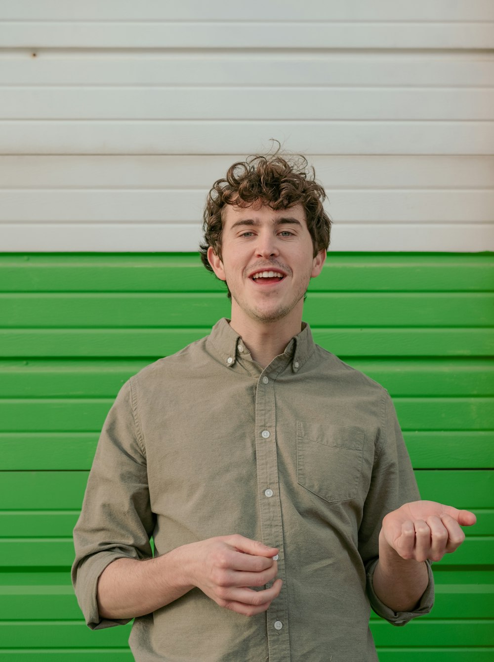 Un homme debout devant un mur vert