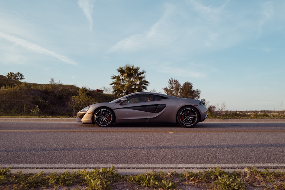 black coupe on gray asphalt road under blue and white sunny cloudy sky during daytime