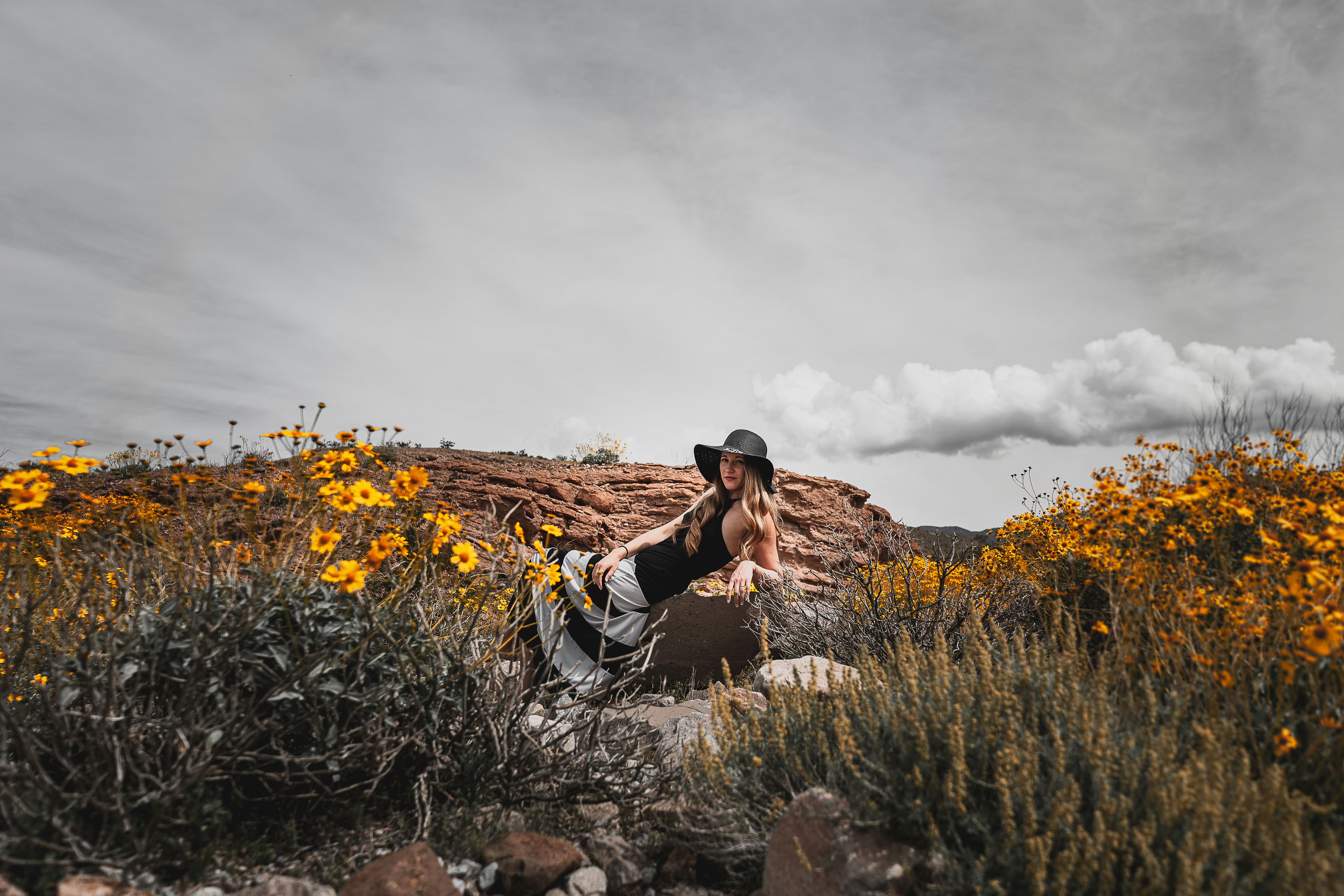 man in black and white shirt sitting on brown rock during daytime