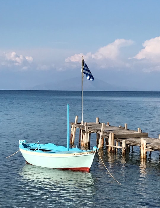 blue and white boat on sea during daytime in Corfu Greece