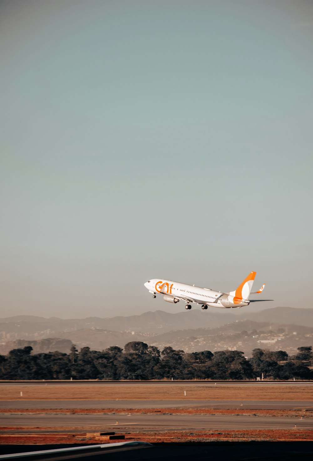 avião branco e laranja no ar durante o dia