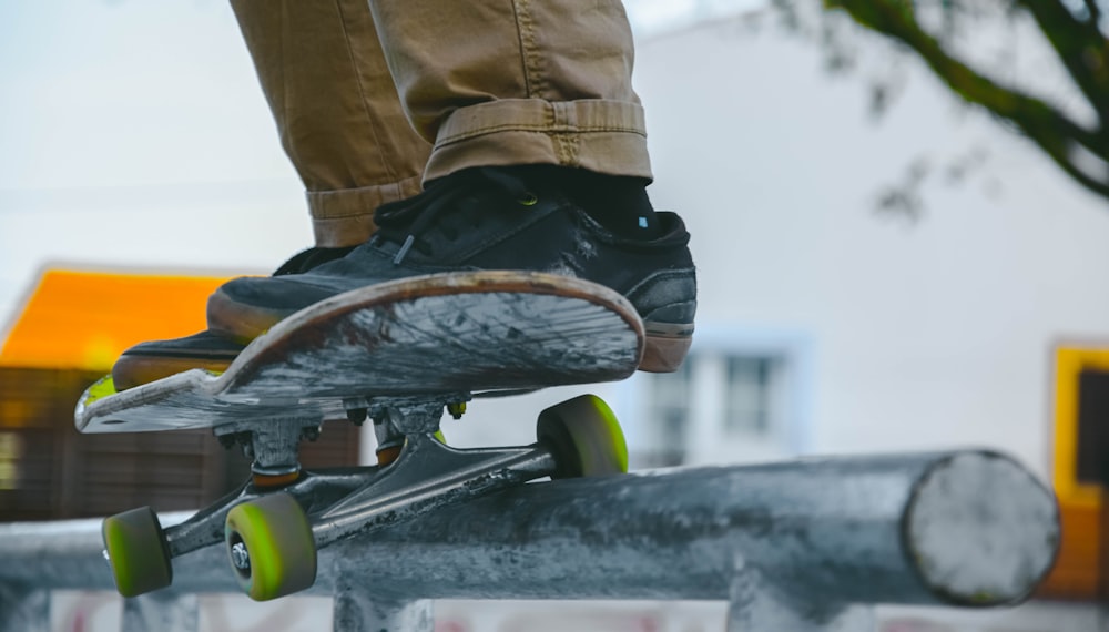 Person in braunen Hosen und schwarzen Schuhen beim Skateboard