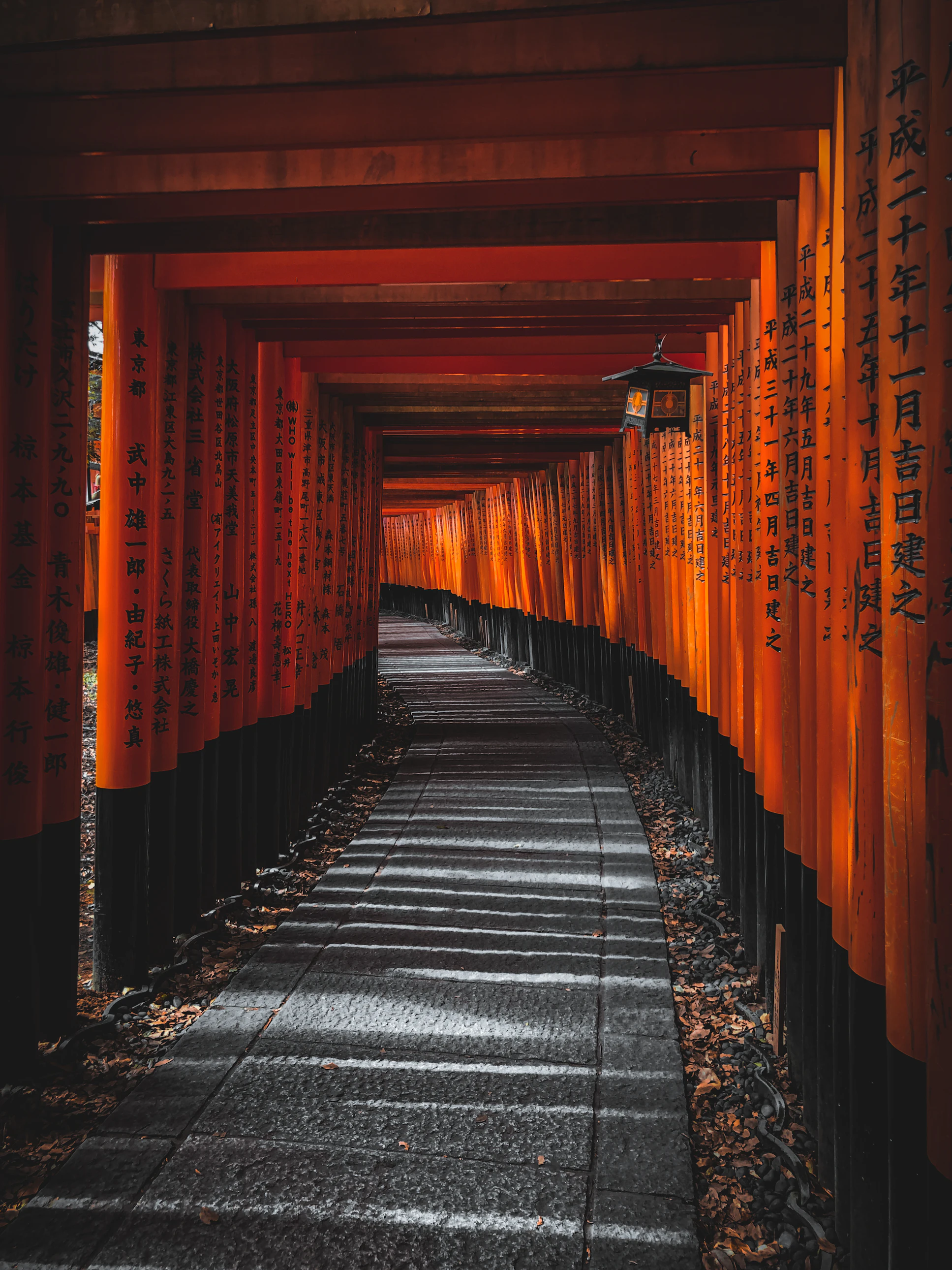 Close-up of orange and black wooden torii gate posts