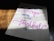 A piece of paper with a handwritten motivational quote in cursive and print styles, displayed on a wooden surface with light and shadow creating a dramatic effect.
