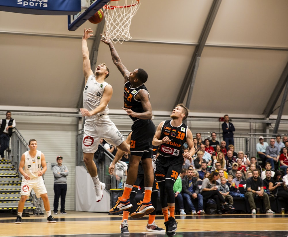 grupo de pessoas que jogam basquete