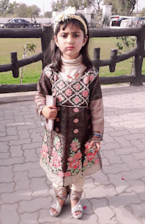 A young girl proudly holding a handmade craft, symbolizing self-reliance and creativity.