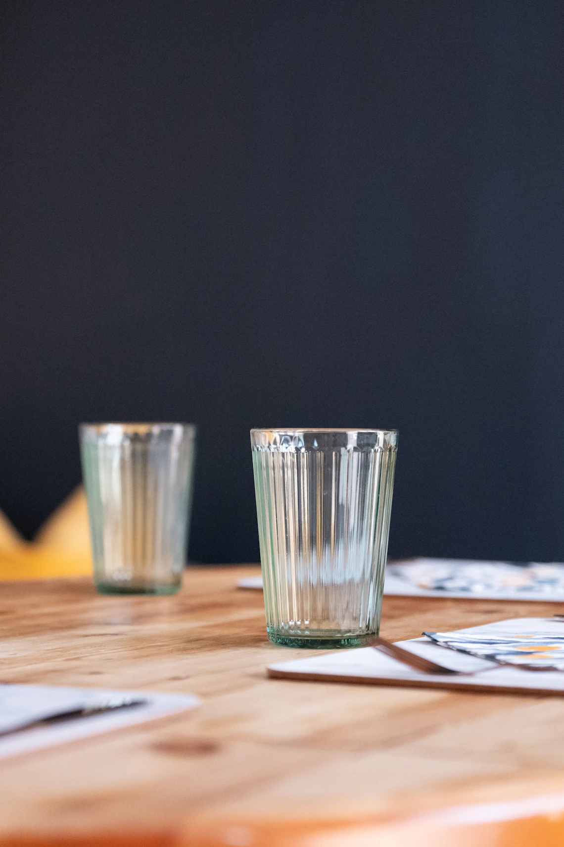 Real clear drinking glasses arranged on a wooden dining table