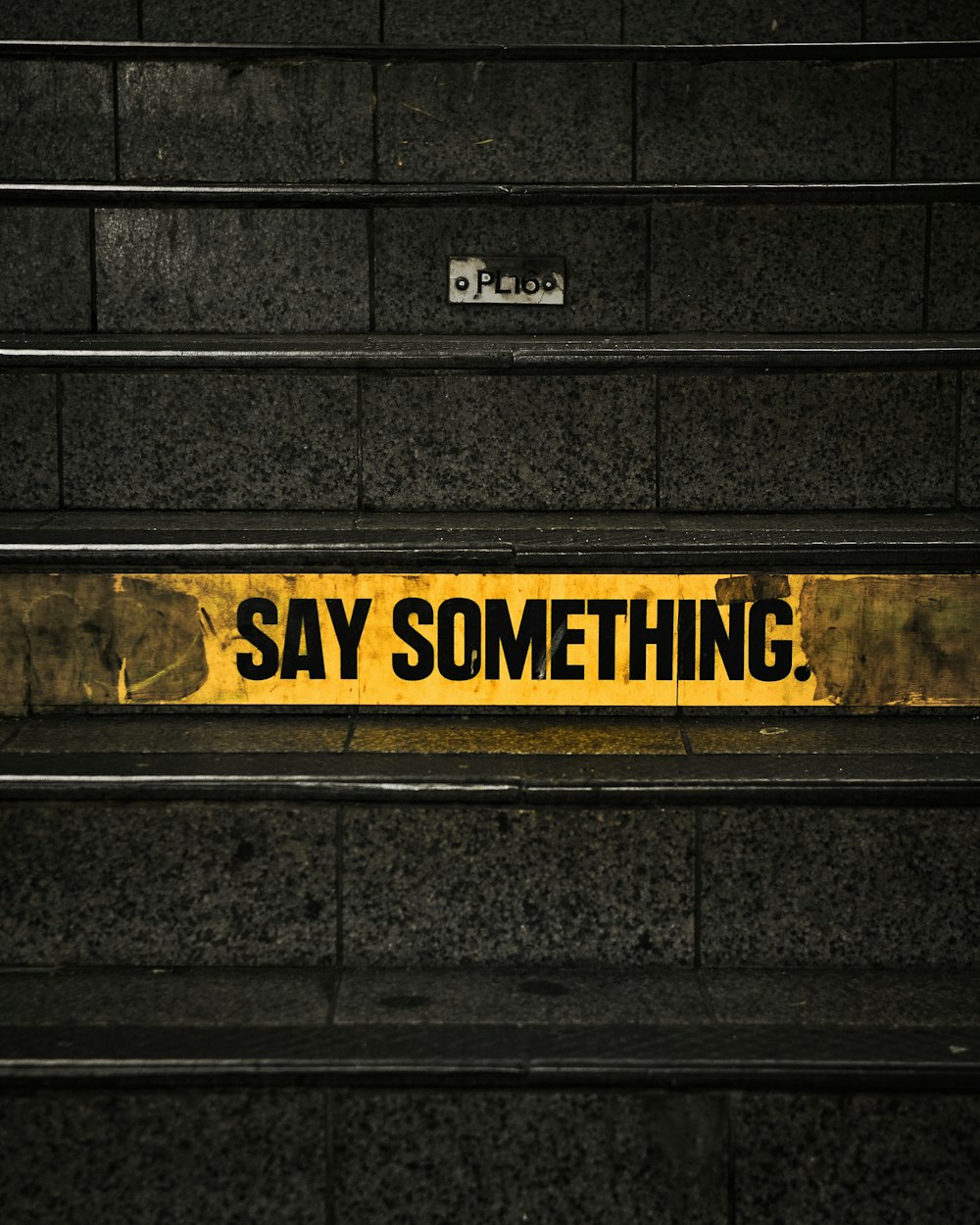 a yellow and black sign that says say something