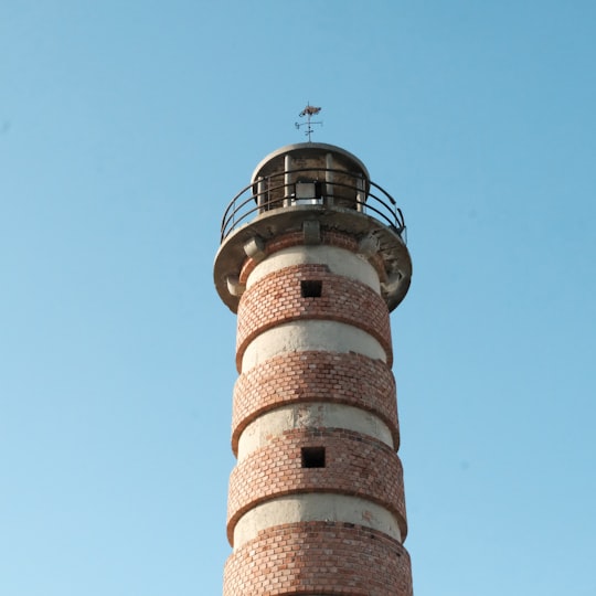 white and brown concrete tower under blue sky during daytime in Belem Lighthouse Portugal