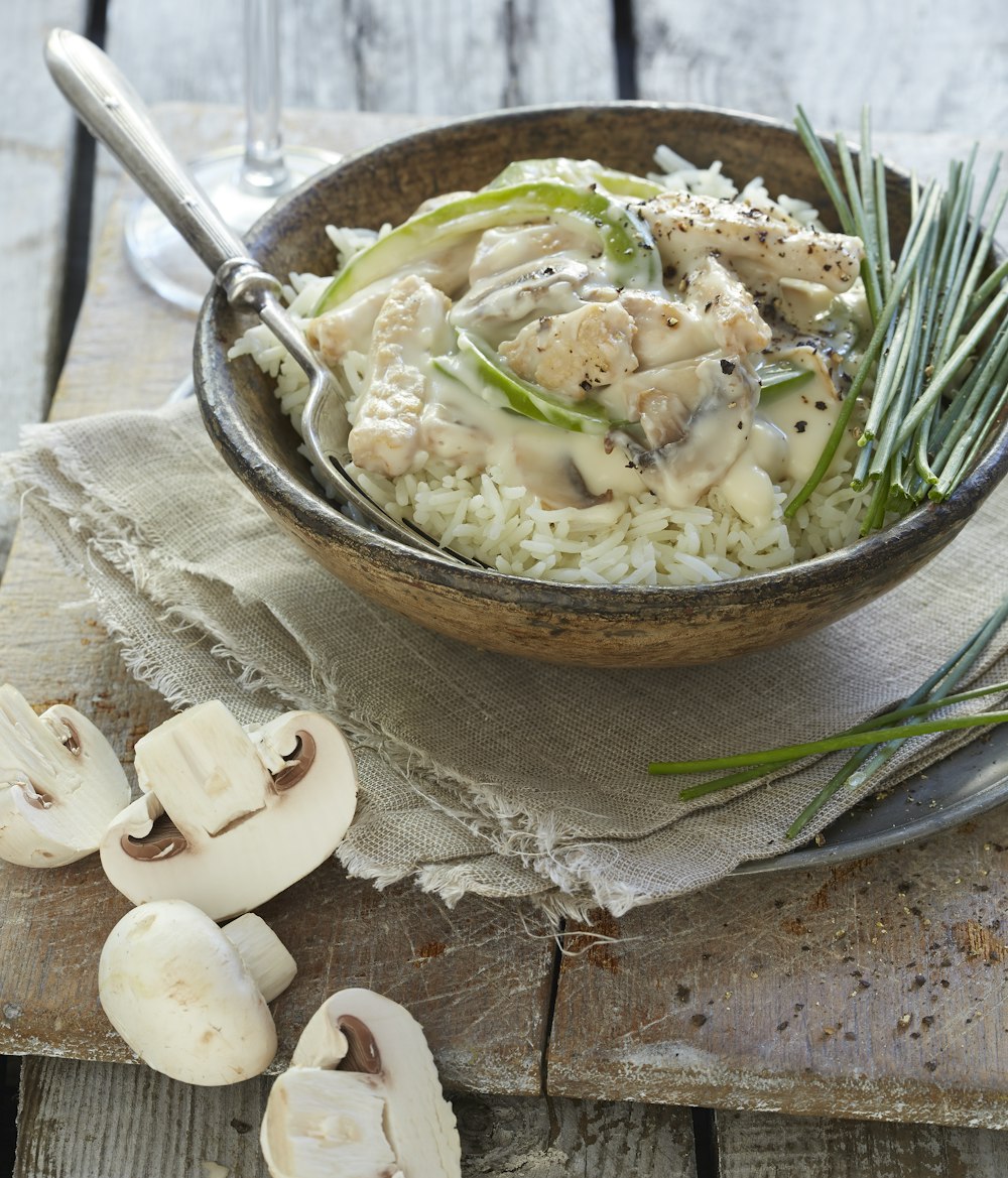 white rice with green leaf vegetable on brown wooden bowl