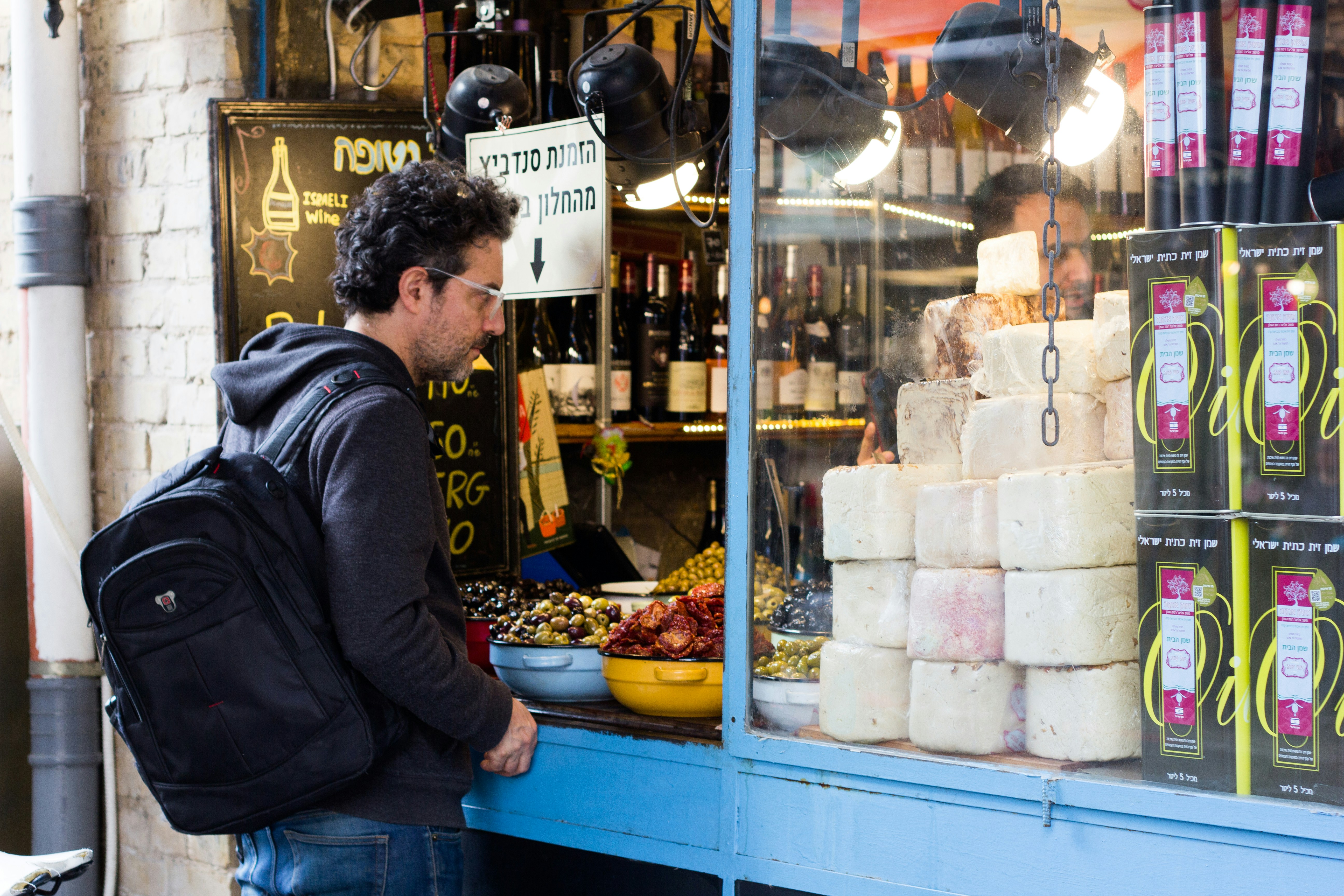 homme en veste noire assis sur une table bleue