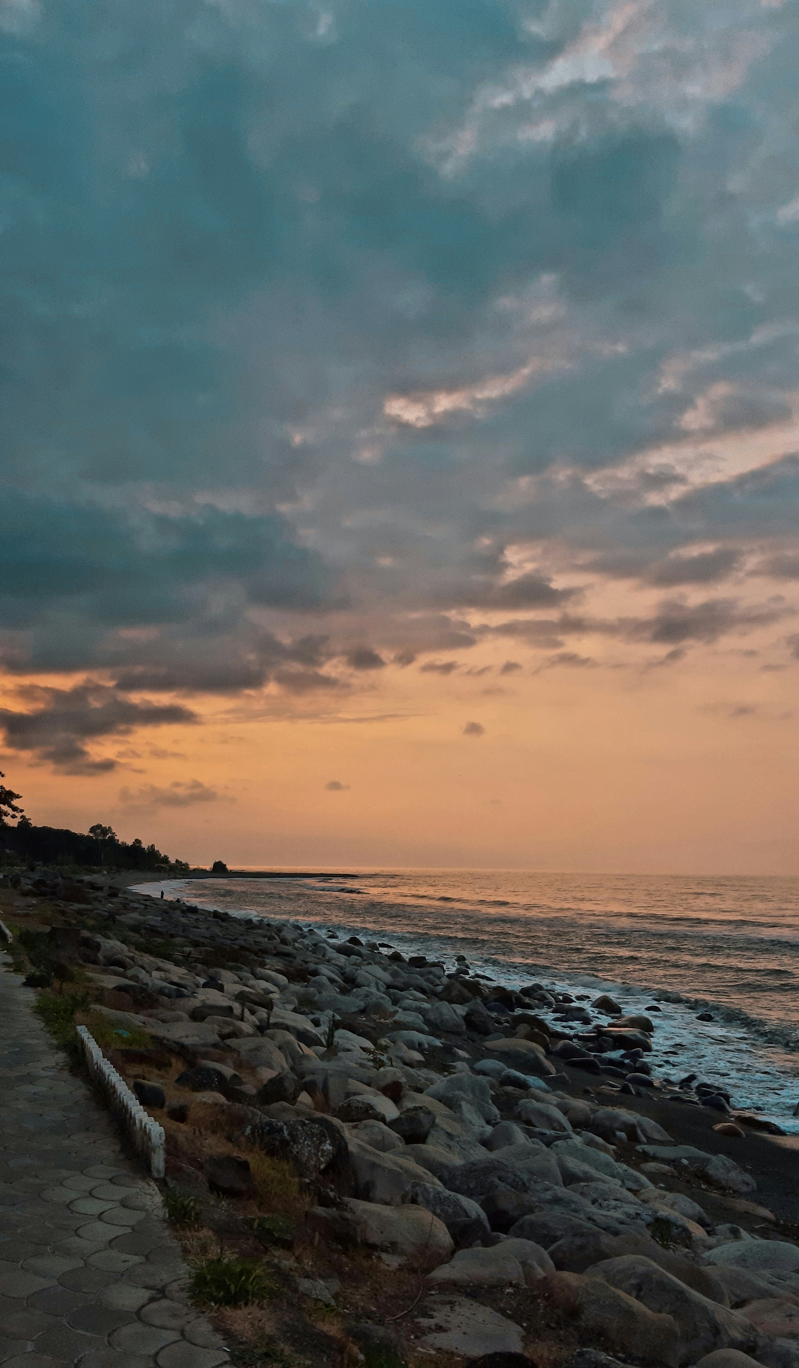 body of water under cloudy sky during sunset