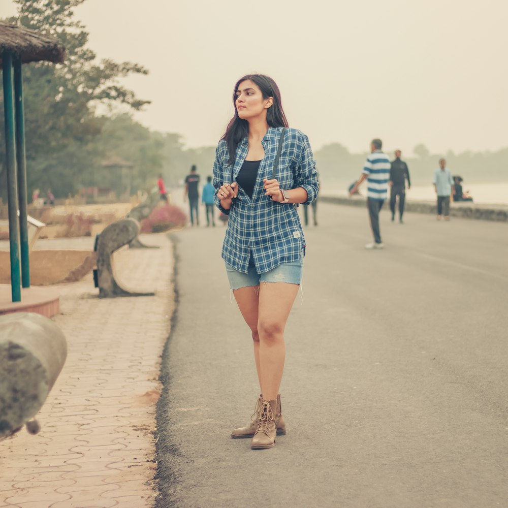 woman in black and white long sleeve shirt standing on road during daytime