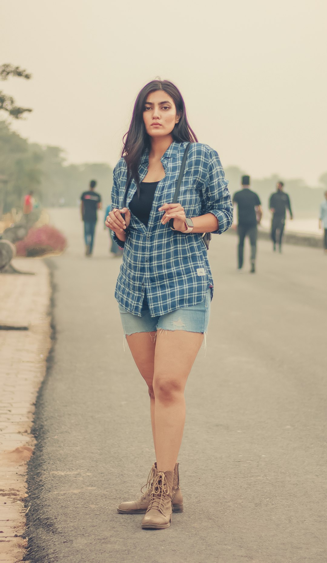 woman in blue and white plaid button up long sleeve shirt and blue denim shorts standing