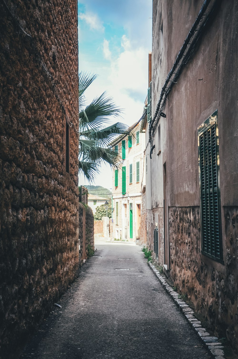 empty road between brick buildings during daytime