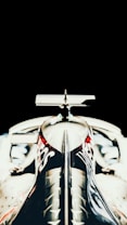 A sleek, aerodynamic front view of a race car with a glossy black finish and distinctive branding on the nose. The image highlights the symmetry and precision of the vehicle, set against a stark black background.