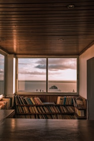 brown wooden book shelf near window