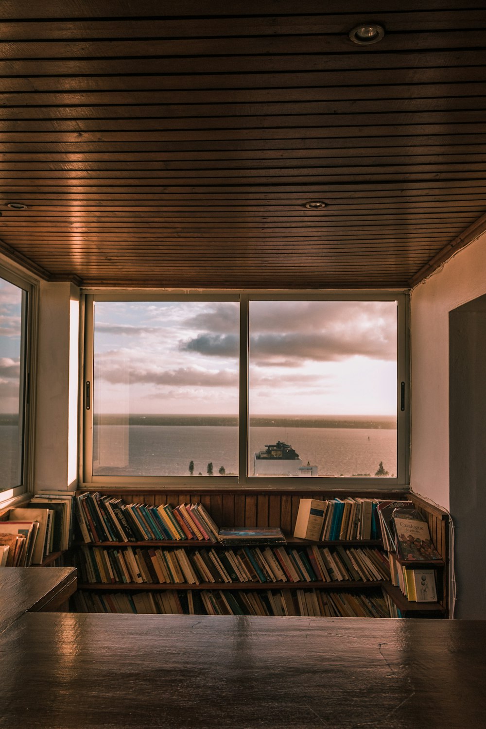 brown wooden book shelf near window