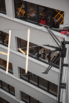 Modern office building with visible wireless network infrastructure and employees working on laptops.