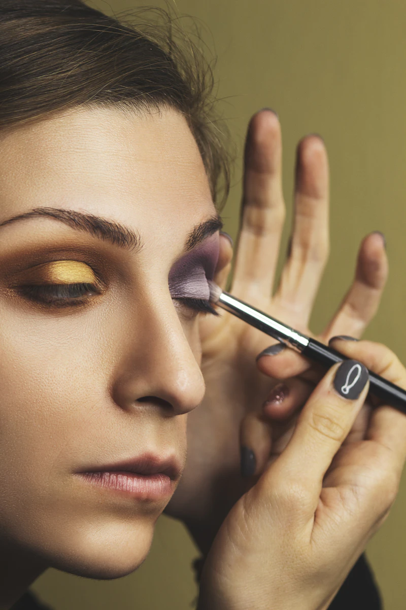 Makeup artistry student blending an editorial look