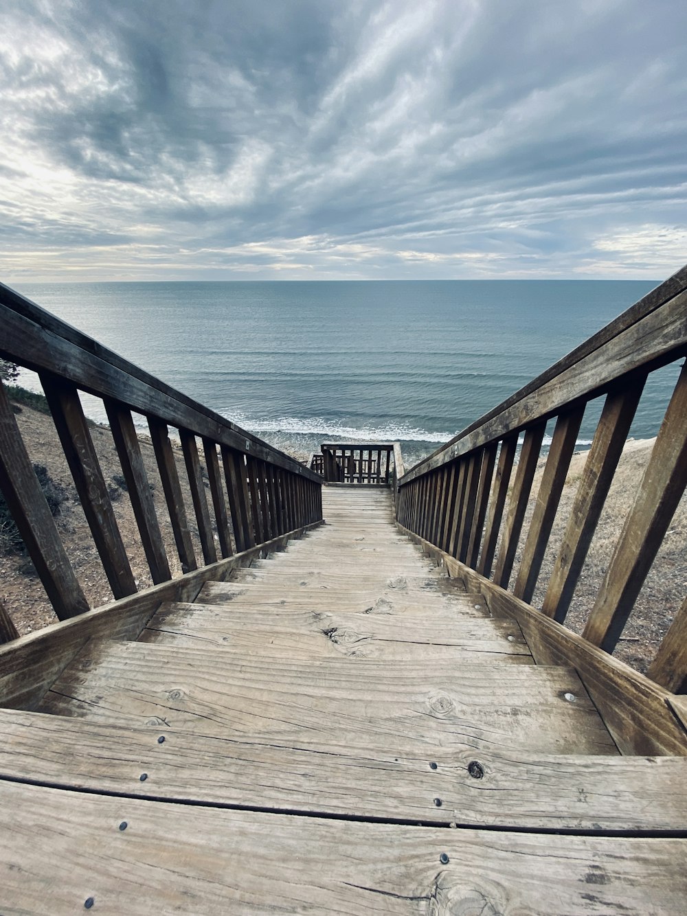 brown wooden dock on sea under blue sky during daytime