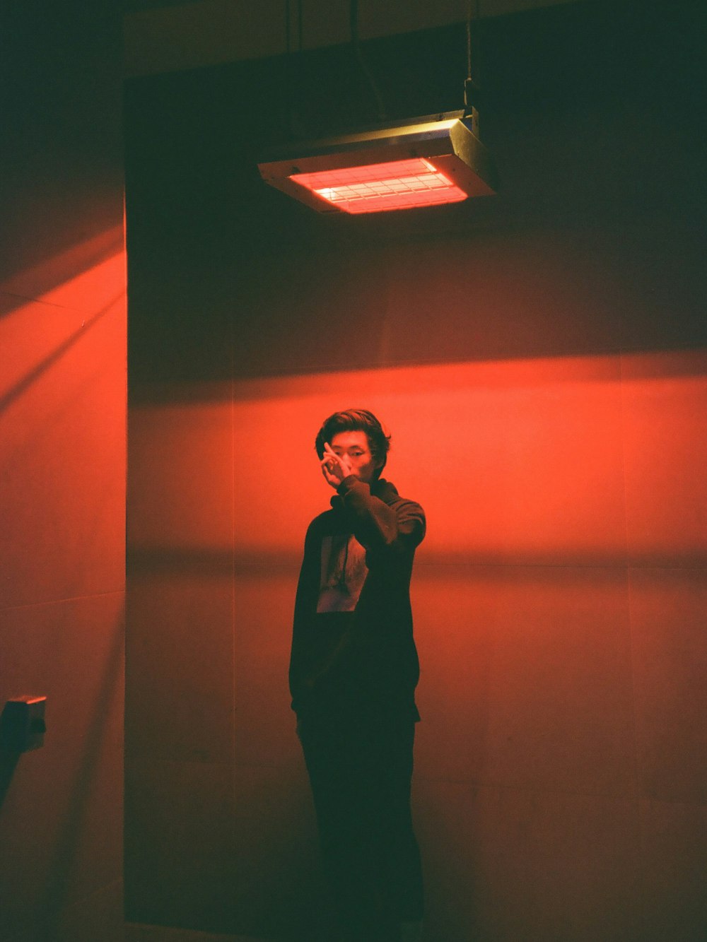 woman in black dress standing in front of brown wall