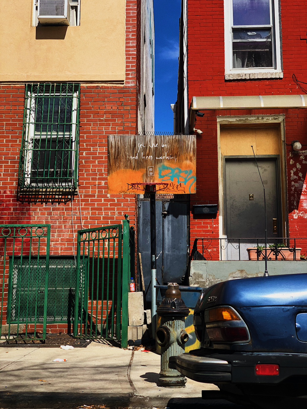 black car parked beside brown concrete building during daytime