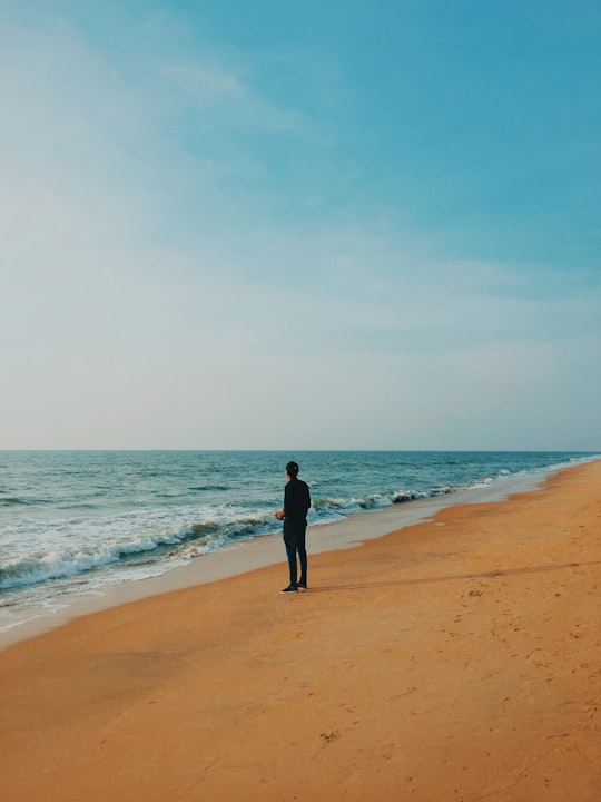 man in black shirt walking on beach during daytime in Ernakulam India