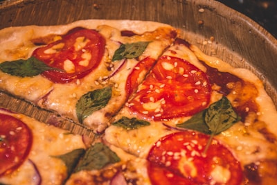 Close-up of a freshly baked pizza topped with vibrant tomatoes and basil.