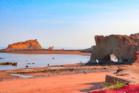 brown rock formation on body of water during daytime in Hormuz Island Iran