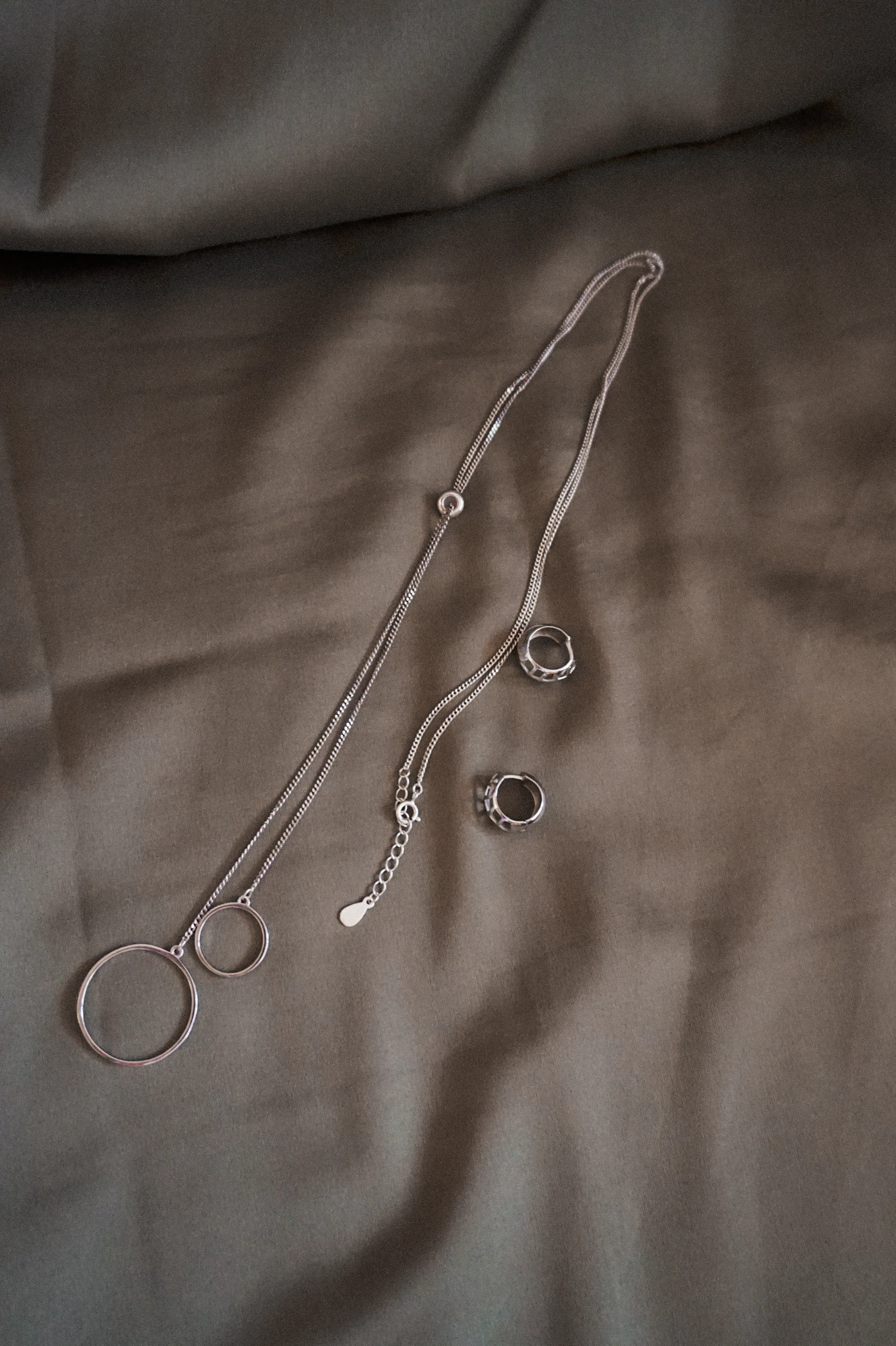 Silver necklace on white textile, a sterling silver chain