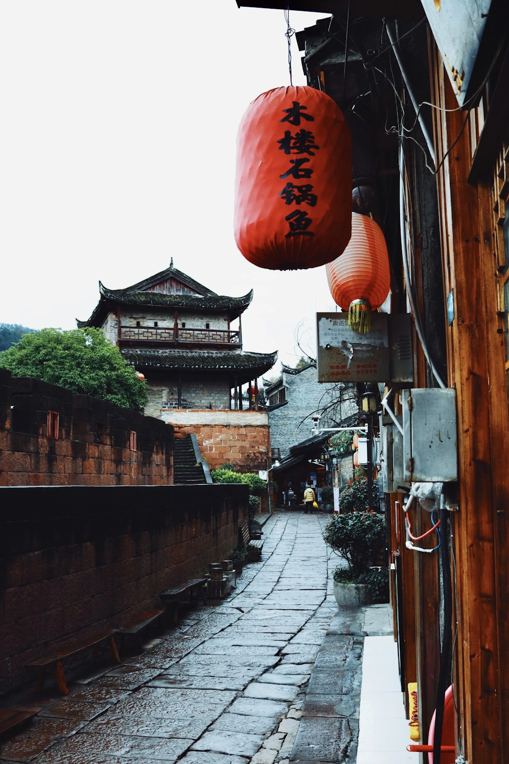 red paper lantern hanging on brown wooden post