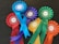 A collection of colorful award ribbons, each labeled as a winner. The ribbons are of various colors including red, blue, purple, green, yellow, and orange, arranged on a dark surface. Each ribbon is marked with different event names such as 'Conaccord Stakes' and 'The Sand Race'.