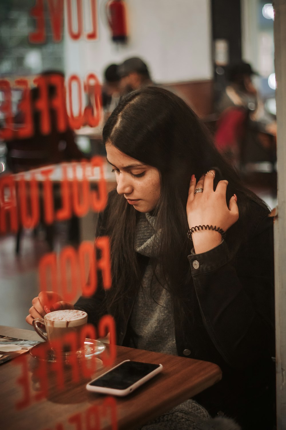 woman in black coat sitting by the table