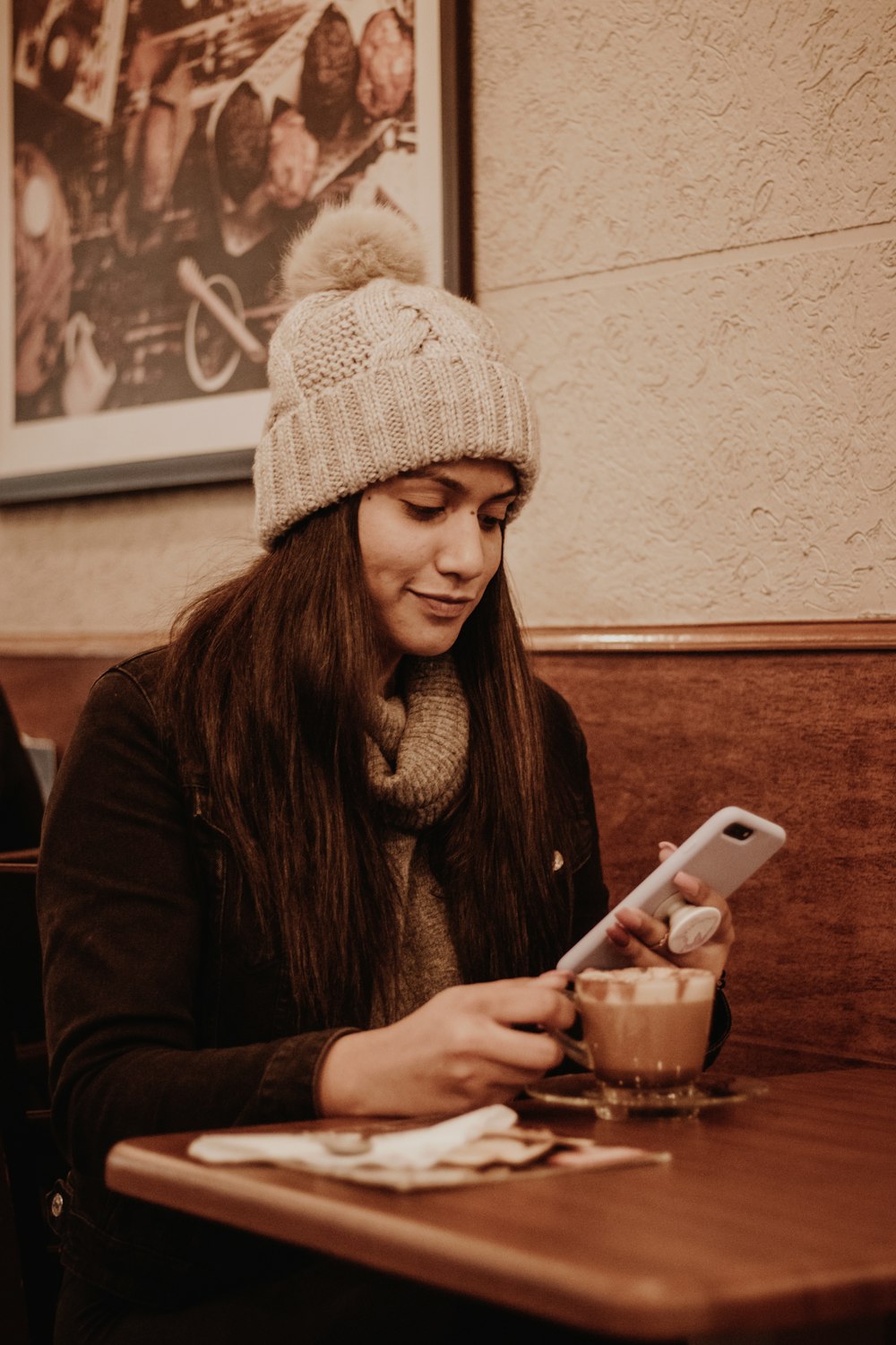 woman in brown sweater holding white ceramic mug