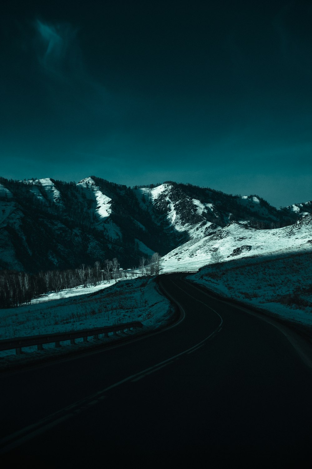 gray road near snow covered mountain during daytime