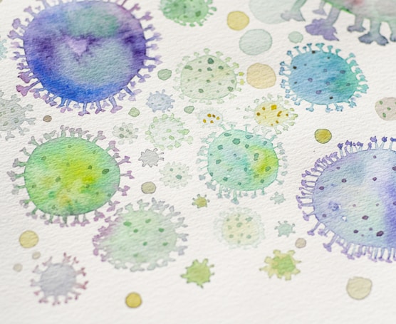Watercolor illustration depicting various abstract, circular shapes resembling microscopic views of viruses or cells in shades of green, blue, and purple.