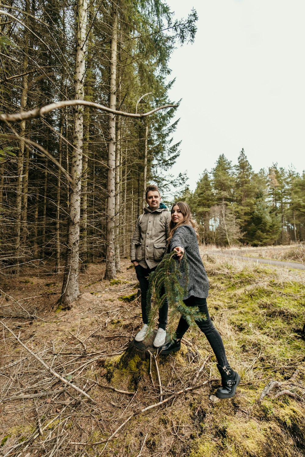 woman in green jacket and black pants walking on green grass field surrounded by trees during