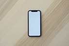 white smartphone on brown wooden table