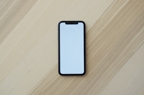white smartphone on brown wooden table