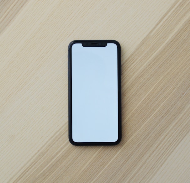 white smartphone on brown wooden table