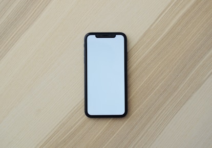 white smartphone on brown wooden table