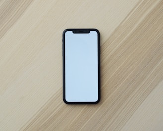 white smartphone on brown wooden table